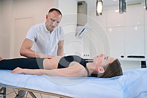 Beautiful Caucasian lady on massage table getting physiotherapy session in wellness center