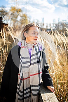 Beautiful caucasian middle aged woman relaxing in autumn cold windy weather. lifestyle portrait in nature.