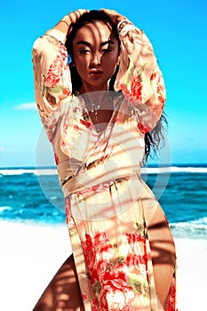 Beautiful caucasian sunbathed woman model with dark long hair posing on summer beach