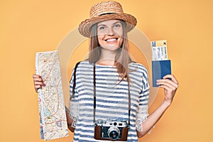 Beautiful caucasian tourist woman holding city map and passport smiling with a happy and cool smile on face