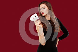 Beautiful caucasian woman in black dress with poker cards gambling in casino