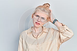 Beautiful caucasian woman with blond hair wearing casual look and glasses confuse and wonder about question