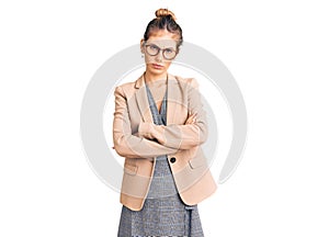 Beautiful caucasian woman with blonde hair wearing business jacket and glasses skeptic and nervous, disapproving expression on