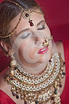 Beautiful caucasian woman with braided hair dressed in Indian bridal Sari along with specific jewelry