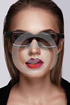 Beautiful caucasian woman with creative makeup in the color of an instagram pattern on her lips. Beauty face. Art makeup