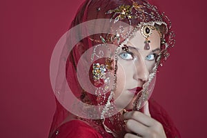 Beautiful caucasian woman dressed in Indian bridal Sari along with specific jewelry: Mangalsutra, Thaali, Maang Tikka, Choora, Nat