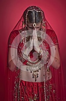 Beautiful caucasian woman dressed in Indian bridal Sari along with specific jewelry: Mangalsutra, Thaali, Maang Tikka, Choora, Nat