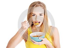 Beautiful caucasian woman eating cereals.