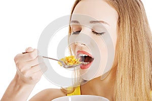 Beautiful caucasian woman eating cereals.