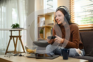 Beautiful caucasian woman in headset holding joystick playing video game at home