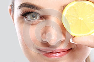 Beautiful caucasian woman holding a slice of lemon