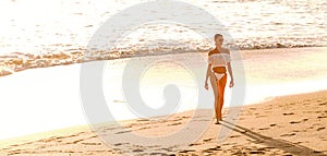 Beautiful caucasian woman ona  relaxing walk on empty beach at sunset sea shore