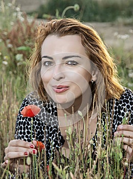 Beautiful caucasian woman posing in poppy flowers field, beauty, fashion and nature