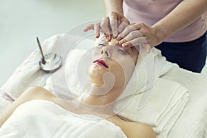 Beautiful caucasian woman relaxation and lying, spa massage on face in spa salon