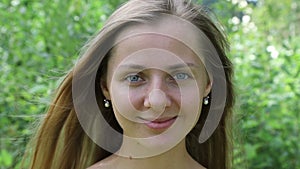 Beautiful caucasian woman smiling sweetly, face close-up. Slow motion