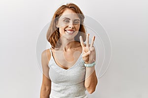 Beautiful caucasian woman standing over isolated background showing and pointing up with fingers number three while smiling