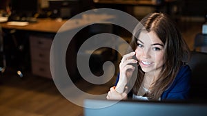 Beautiful caucasian woman talking on a cell phone at a workplace. Portrait of a business woman in the office