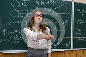 Beautiful caucasian woman teacher standing in classroom near chalkboard