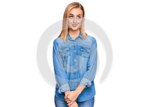 Beautiful caucasian woman wearing casual denim jacket smiling looking to the side and staring away thinking