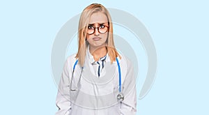 Beautiful caucasian woman wearing doctor uniform and stethoscope depressed and worry for distress, crying angry and afraid