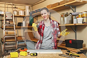 Beautiful caucasian young brown-hair woman working in carpentry workshop at table place. photo