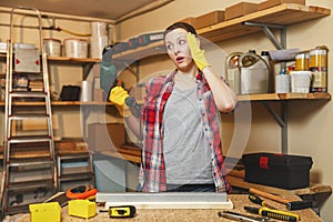 Beautiful caucasian young brown-hair woman working in carpentry workshop at table place. photo