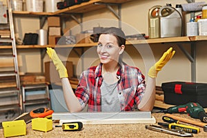 Beautiful caucasian young brown-hair woman working in carpentry workshop at table place.