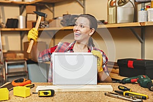 Beautiful caucasian young brown-hair woman working in carpentry workshop at table place.