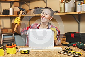 Beautiful caucasian young brown-hair woman working in carpentry workshop at table place.