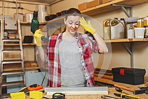 Beautiful caucasian young brown-hair woman working in carpentry workshop at table place. photo