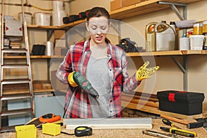 Beautiful caucasian young brown-hair woman working in carpentry workshop at table place. photo