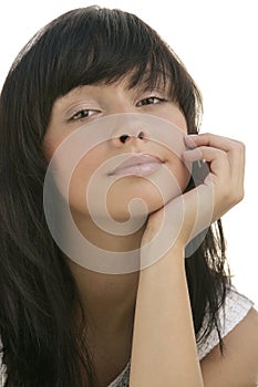 Beautiful Caucasian young female model with long dark hair resting chin on her hand