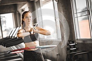 Beautiful caucasian young woman doing hula hoop in step waist hooping forward stance. Young woman doing hula hoop