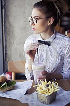 Beautiful caucasian young woman eating lunch fast food fried pot