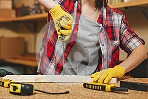 Beautiful caucasian young woman working in carpentry workshop at table place