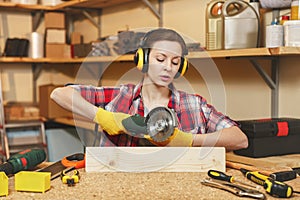 Beautiful caucasian young woman working in carpentry workshop at table place