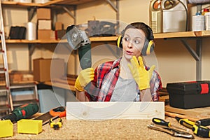 Beautiful caucasian young woman working in carpentry workshop at table place