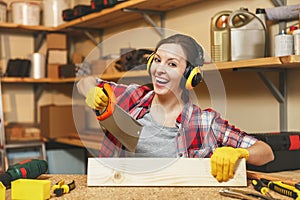 Beautiful caucasian young woman working in carpentry workshop at table place