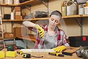 Beautiful caucasian young woman working in carpentry workshop at table place