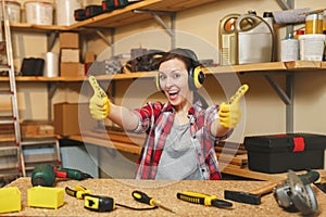 Beautiful caucasian young woman working in carpentry workshop at table place