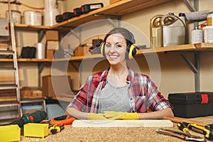 Beautiful caucasian young woman working in carpentry workshop at table place