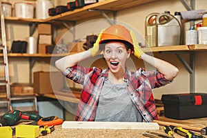 Beautiful caucasian young woman working in carpentry workshop at table place