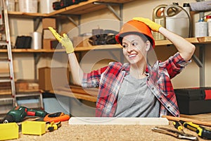 Beautiful caucasian young woman working in carpentry workshop at table place