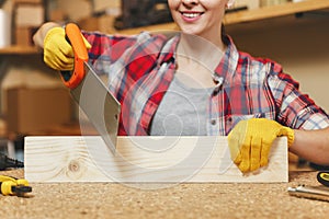 Beautiful caucasian young woman working in carpentry workshop at table place