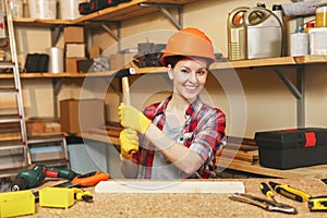 Beautiful caucasian young woman working in carpentry workshop at table place