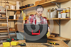 Beautiful caucasian young woman working in carpentry workshop at table place