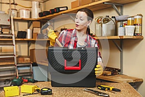 Beautiful caucasian young woman working in carpentry workshop at table place