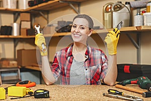 Beautiful caucasian young woman working in carpentry workshop at table place