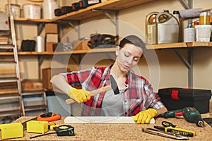 Beautiful caucasian young woman working in carpentry workshop at table place