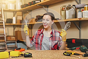 Beautiful caucasian young woman working in carpentry workshop at table place